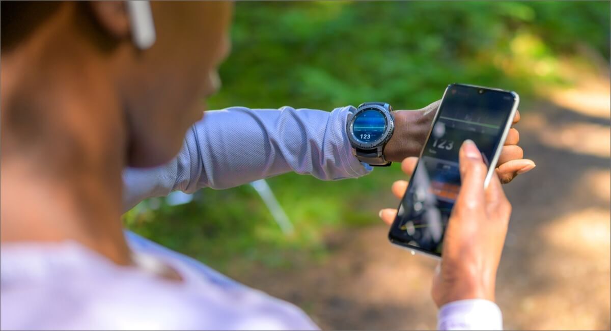 Person looking at smartphone, smart watch with ear buds