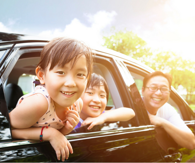 Family in Car Kids and dad hanging out the car window and smiling at the camera
