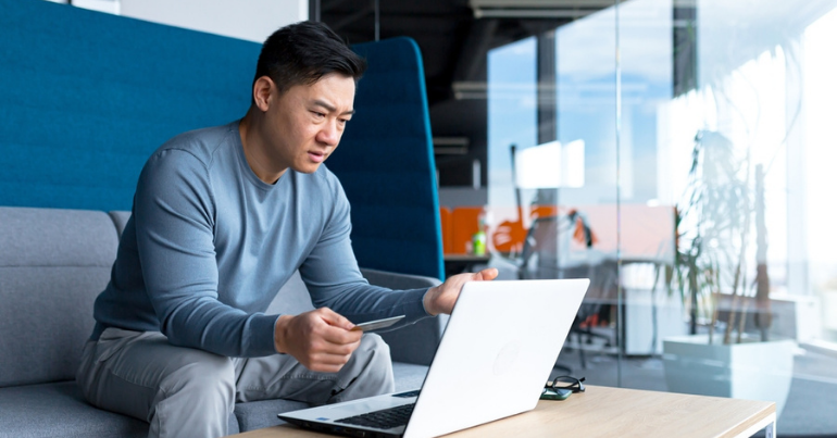 consumer frustration hero man sitting on couch frustrated at laptop