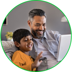 Round Image of son and father watching a laptop while sitting on the couch