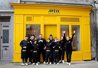 a group of people posing for a photo in front of a yellow building