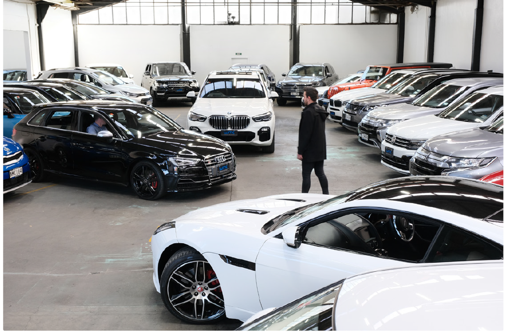 a person standing in a parking lot full of cars